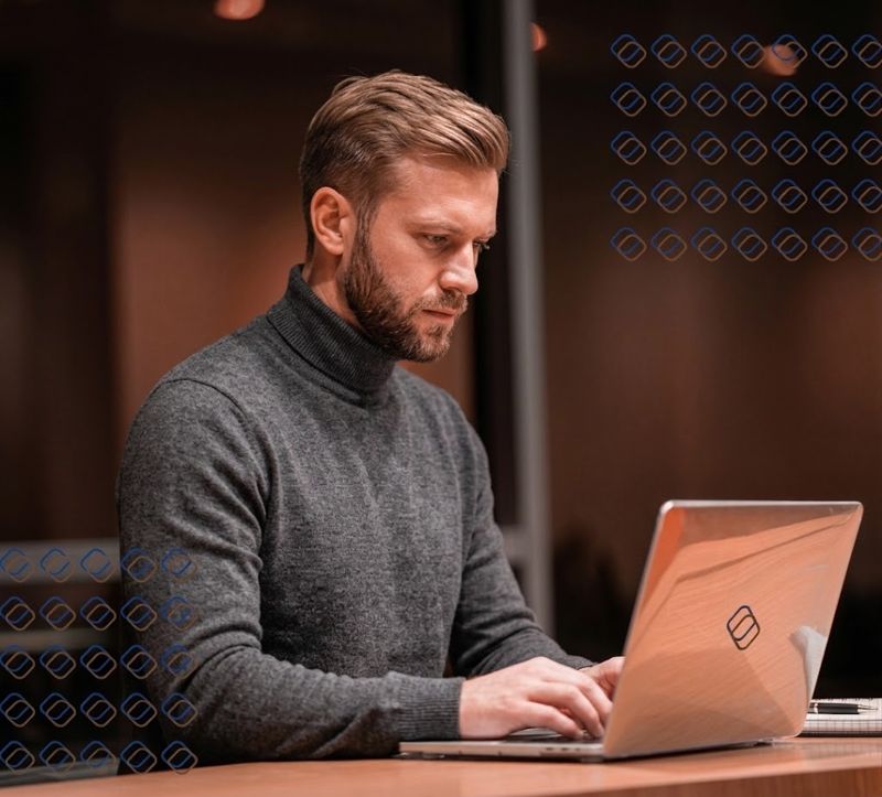 Profissional trabalhando em um notebook em um ambiente corporativo de tecnologia